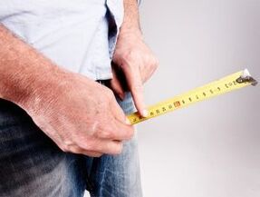 un homme mesure la longueur du pénis avant l'augmentation avec du soda